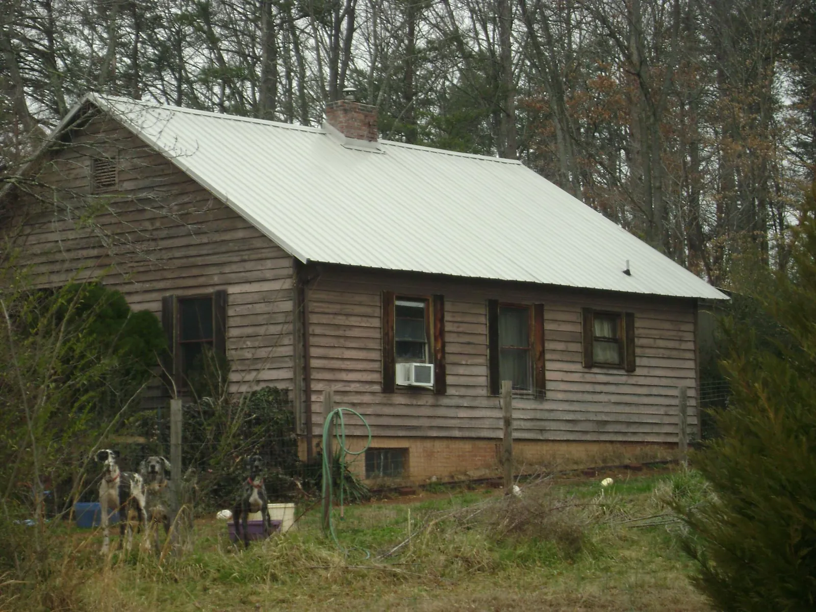 White metal roof on an old wood sided farmhouse, from a Metal Roof Installation job in Belton
